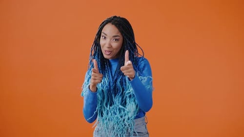 Smiling Woman with Blue Braids Points and Gestures