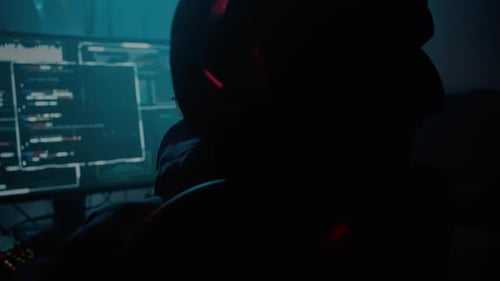 Adult Typing at a Computer in a Dark Room