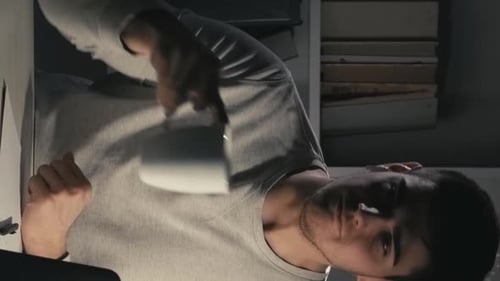 Young Adult Drinking Coffee at Desk at Night