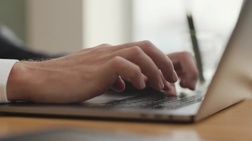Man's Hands Typing on Laptop Computer Keyboard