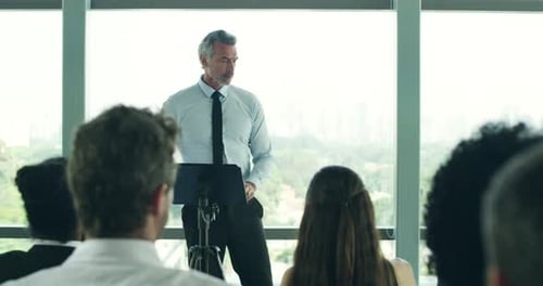 Adult Male Speaker Presents to an Office Audience
