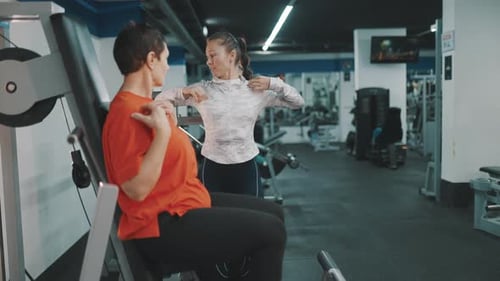 Female Fitness Trainer Teaching Client in a Gym