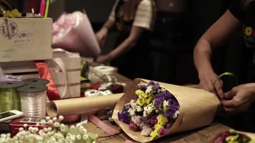 Florist making bouquet of flowers in flower shop in Lviv