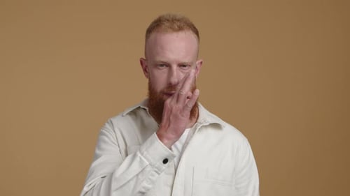 Porträt eines jungen Mannes mit roten Haaren, der eine Geste vor der Kamera zeigt