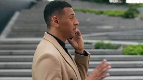 Seitenansicht: Afroamerikanischer männlicher Unternehmer, Arbeitgeber, Kerl, Geschäftsmann in der Stadt, städtischer Geschäftsmann