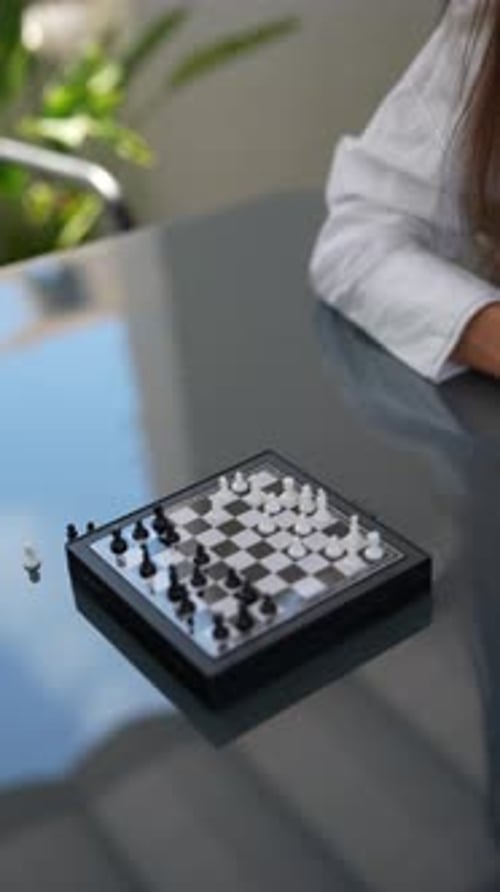 Two People Engaged in a Game of Chess on a Transparent Board Deeply Focused on the Strategic Play