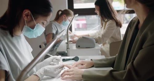 Nail Studio with Professional Masters Doing Manicure for Female Clients