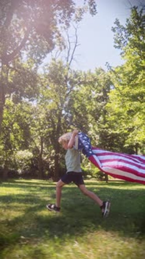 Child Runs with American Flag in Grassy Park