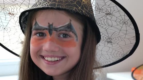 Smiling Child Wearing Witch Hat and Face Paint
