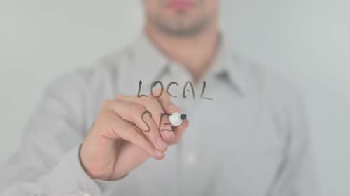 Man Writes Local SEO on Glass Surface
