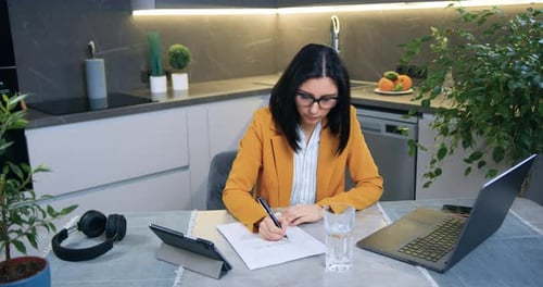 Woman Works on Laptop in Modern Kitchen