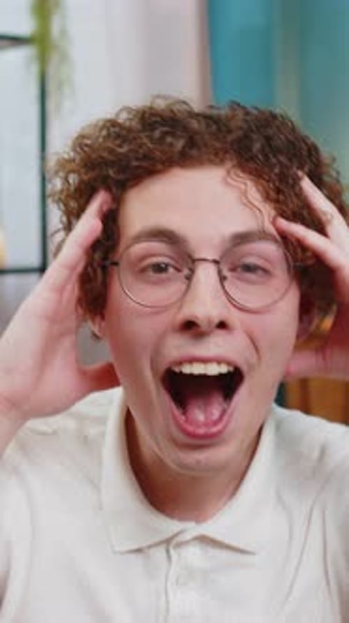 Excited Young Man Smiling Indoors in Home Setting