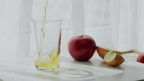 Apple Juice Being Poured into Glass Indoors