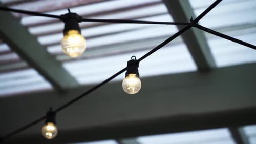 Lit String Of Lightbulbs Hanging From The Ceiling. Selective Focus Shot
