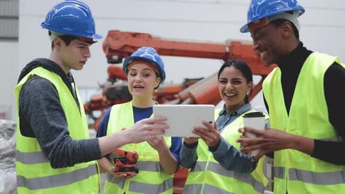Multirassische Ingenieure haben Spaß an der Arbeit in Robotik- und Automatisierungsanlagen - Industrial Tech