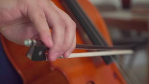 close up musician hands playing cello