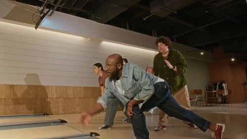 Mädchen treten auf der Bowlingbahn gegen Jungs an und feiern zusammen