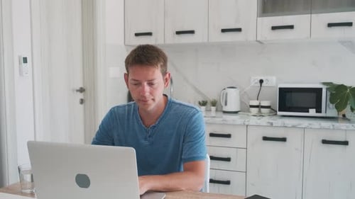 Man Working on Laptop in Modern Kitchen