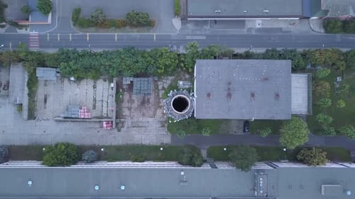 Aerial climbing shot of an Old industrial park with high chimney in a sub-urban territory.