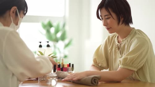 Woman Receiving a Manicure at a Bright Nail Salon