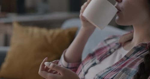 Woman Drinks from Mug at Home