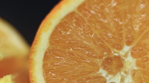 Orange fruit sliced up, Juicy detailed segments, pan movement, 120 fps slow motion, studio light