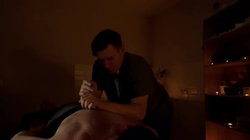 A Professional Massage Therapist Does a Massage with His Hands Men's Back Spa Salon By Candlelight