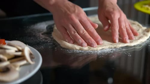 Frauen machen Teig in Form von Pizza