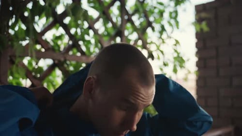 Young Man Puts On Blue Hooded Jacket