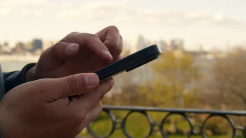 Man Typing On Smartphone During Leisure Walk Through Halifax City Center