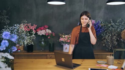 Young Woman Florist in a Flower Shop Orders Flowers From the Greenhouse to Be Delivered Fresh to the