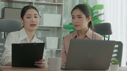 Two Young Enthusiastic Businesswoman Working Together in the Office Workspace