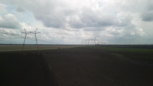 Aerial View of Power Lines Over Green Agricultural Field
