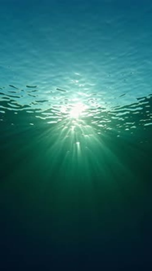 La lumière du soleil illumine la mer sous la surface par temps calme en contre-jour