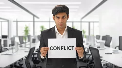 Young Adult Holds Conflict Sign in Empty Office