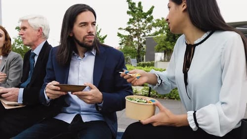 Business people with different ages having a lunch break outside office