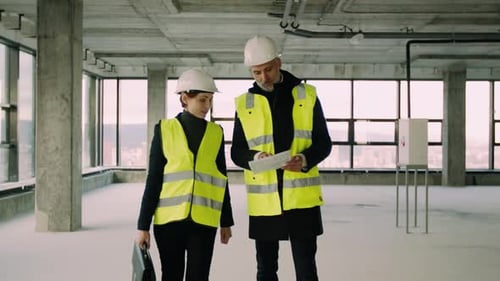 Architects Reviewing Building Plans in Unfinished High Rise
