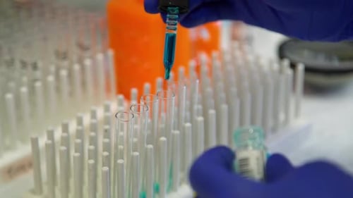 Blue Liquid Being Pipetted Into Test Tubes