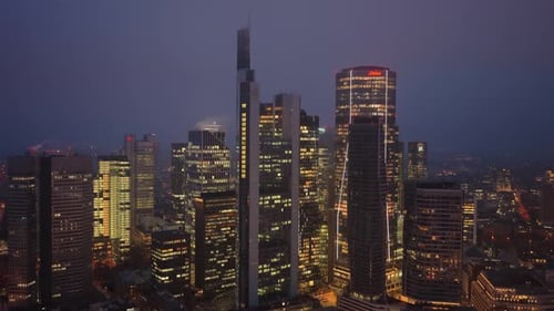 Aerial Footage of Illuminated Frankfurt Skyline at Dusk Modern Skyscrapers and High Rise Office