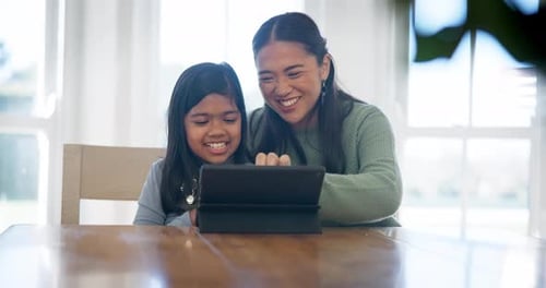 Woman and Girl Happily Use Tablet at Table
