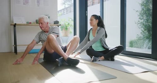 Man and Woman Stretching on Yoga Mats Indoors