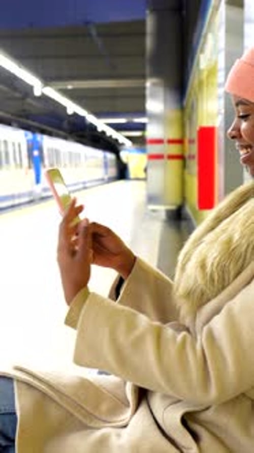 Young Woman Using Smartphone While Waiting for Subway
