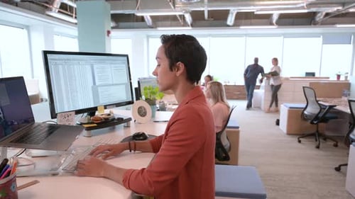 Young african american businesswoman works at laptop on sitstand desk in office