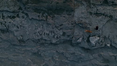 A Red Dog Walks with His Mistress on a Stone Beach in the Most Beautiful Sunset Aerial View