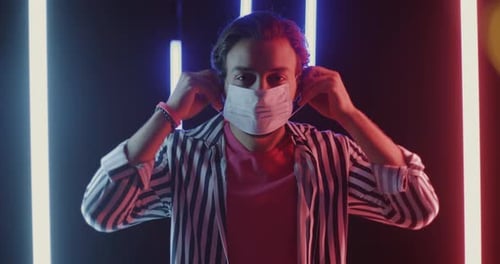 Young Adult Puts on a Surgical Mask