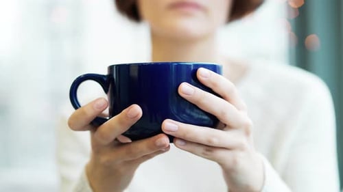 Woman Holding a Large Blue Mug Indoors