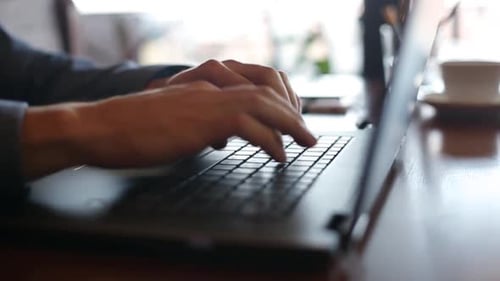 Man Typing on a Laptop in Office