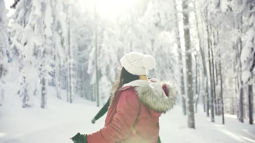 Young friends enjoying winter walk in snowy forest landscape