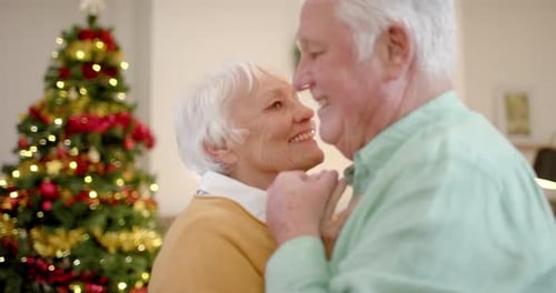Senior Couple Dancing Lovingly Near Christmas Tree