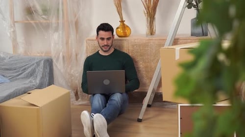 Young Man Using Laptop During Home Renovation